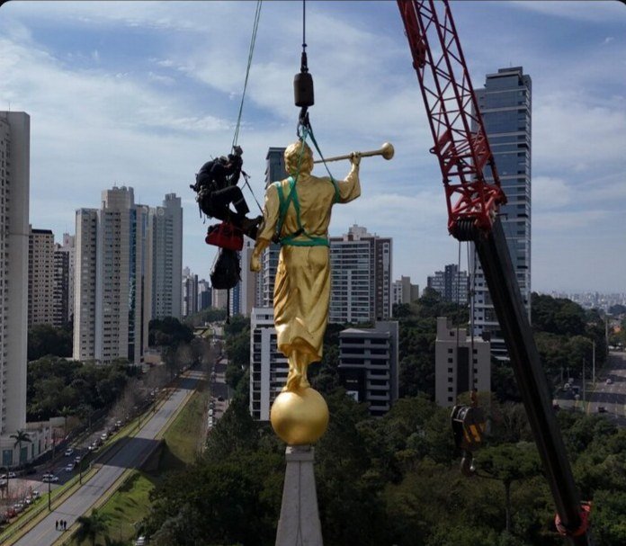 The rope technician guides the statue at the pinnacle