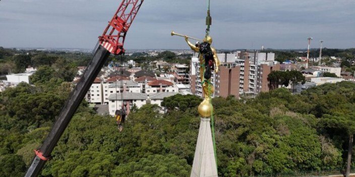 Crane and team at the pinnacle, with the city behind